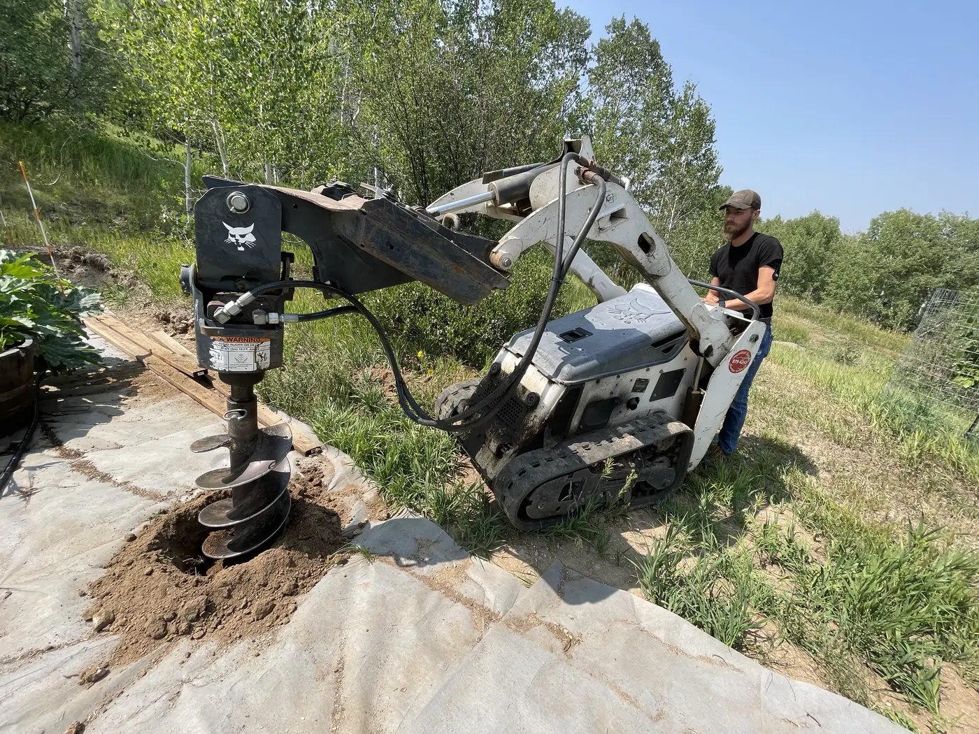 Skid steer grading and moving material on a landscape construction project
